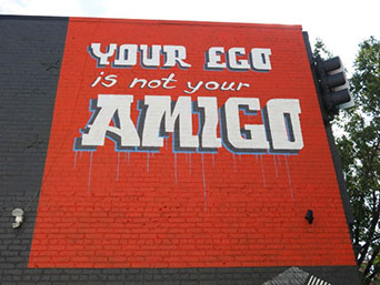 Quote: "Your ego is not your amigo" -- painted on a brick wall.