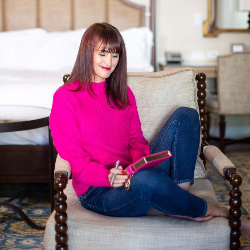 Photo of author Gretchen Hydo sitting comfortbly in a chair.