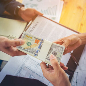 person handing large stack of hundred-dollar bills to another person.