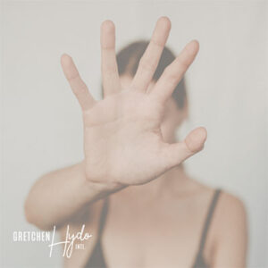 Woman with her hand raised in front of her face in a motion indicating "stop."