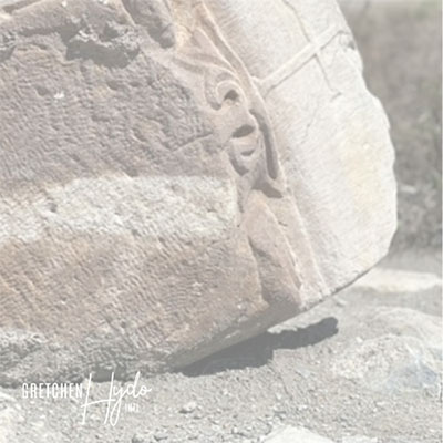 corner of a large boulder sitting on a patch of gravel